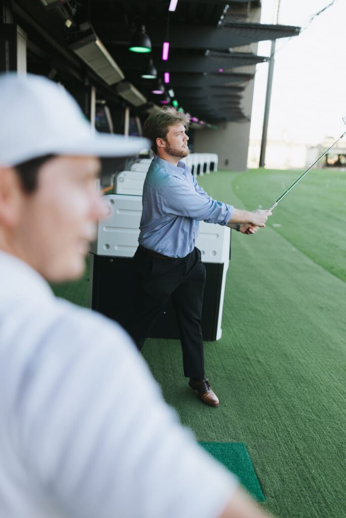 man golfing in blue button down.